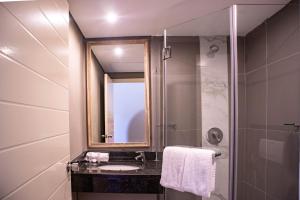 a bathroom with a sink and a shower with a mirror at Regal Inn Ballito in Ballito +13 photos