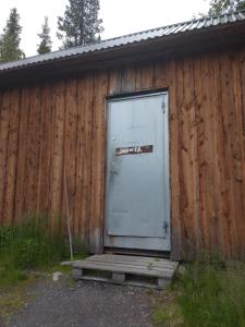 a door on a building with a wooden fence at JVT Cabins in Kiruna