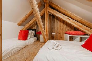 two beds in a attic room with wooden beams at Cabane Malou - Avec jardin et à 200 m des pistes in La Salle-les-Alpes