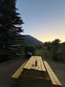 a wooden bench sitting on the side of a road at Cabane Malou - Avec jardin et à 200 m des pistes in La Salle-les-Alpes