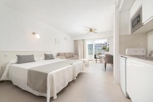 a white hotel room with a bed and a kitchen at Apartamentos Siesta I in Port d'Alcudia +52 photos