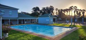 a swimming pool in a yard next to a house at Monique's Place Plett in Plettenberg Bay