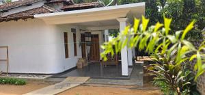 a small white house with a porch at Queens luma villa in Arugam Bay