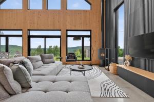 a living room with a couch and a tv at Panoramic View - Spa - L'Espace-temps in Saint Come