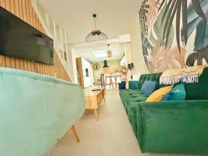 a living room with a green couch and a table at L'Échappée Croisienne in Croix