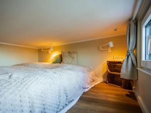 a bedroom with a white bed and a window at Tiny Haus Schwalbe in Groß Kordshagen