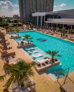 an overhead view of a swimming pool with chairs and palm trees at ibis Styles Arad in Arad