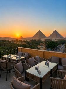 a view of the pyramids at sunset from a restaurant at New Gardenia Pyramids - Rooftop in Cairo