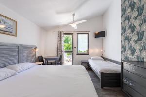 a hotel room with two beds and a tv at Hôtel Le Parasol in Ars-en-Ré +53 photos