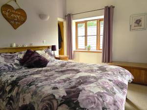 a bedroom with a bed with a floral comforter and a window at 5 Bed in Garth oc-c44957 in Garth