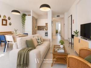 a living room with a white couch and a table at Wanderlust Experience Pumetta Apartment in Bitonto