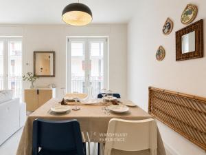 a dining room with a table and blue chairs at Wanderlust Experience Pumetta Apartment in Bitonto