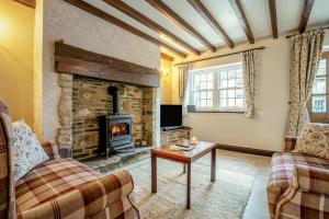 a living room with a fireplace and a couch and a table at 2 Bed in Leyburn oc-n41362 in Leyburn