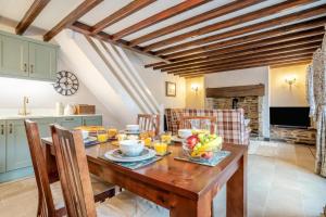 a kitchen and dining room with a wooden table with fruit on it at 2 Bed in Leyburn oc-n41362 in Leyburn