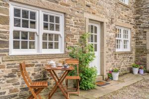 a table and chairs in front of a brick house at 2 Bed in Leyburn oc-n41362 in Leyburn