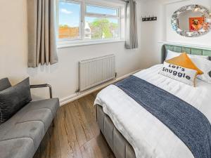 a bedroom with a bed and a couch at 4 Bed in Dothan Ty Croes oc-m44701 in Llanfaelog
