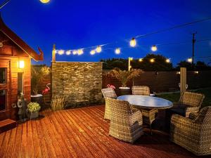 a patio with a table and chairs on a deck at 4 Bed in Dothan Ty Croes oc-m44701 in Llanfaelog