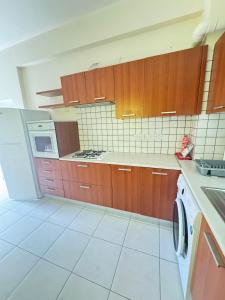 a kitchen with wooden cabinets and a stove top oven at Theodorou Town Residence in Strovolos