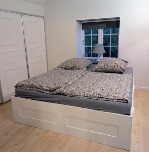a large bed in a bedroom with a window at HyggeHome Strandelhjørn in Vojens