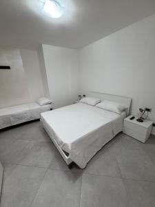 ein Schlafzimmer mit zwei Betten in einem weißen Zimmer in der Unterkunft Villa ManuCamp in Reggio di Calabria