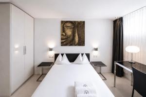 a bedroom with a white bed and a painting on the wall at VISIONAPARTMENTS Binzmühlestrasse 50 - self check-in in Zurich