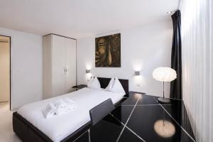 a bedroom with a bed and a table with a lamp at VISIONAPARTMENTS Binzmühlestrasse 50 - self check-in in Zurich