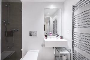 a white bathroom with a sink and a mirror at VISIONAPARTMENTS Binzmühlestrasse 50 - self check-in in Zurich +30 photos