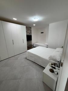 ein weißes Schlafzimmer mit Bett und weißen Schränken in der Unterkunft Villa ManuCamp in Reggio di Calabria