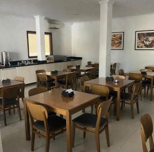 a dining room with wooden tables and chairs at Chimarrão Hotel in Juazeiro
