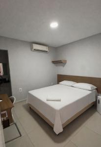 a bedroom with a large white bed in a room at Chimarrão Hotel in Juazeiro +2 photos