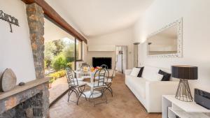 a living room with a white couch and a table and chairs at VILLA ALTHAEA 6, Emma Villas in Orbetello