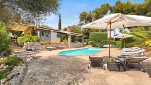 a house with a swimming pool with chairs and an umbrella at VILLA ALTHAEA 6, Emma Villas in Orbetello