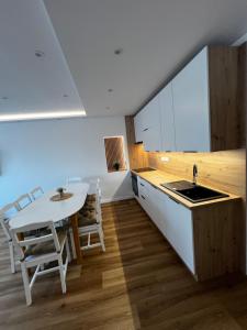 a kitchen with a white table and a table and chairs at Chalupa Veselí in Veselí nad Moravou