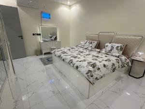 a white bedroom with a bed and a mirror at سويت لافندر in Abha