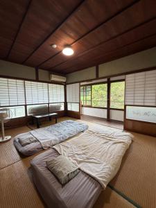 a large bed in a room with windows at 未来のふるさと村 in Yamaguchi