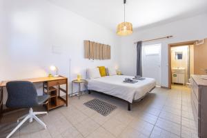 a bedroom with a bed and a desk and a desk at Local Guesthouse in Sagres