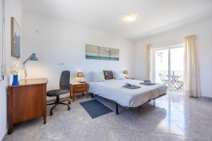a bedroom with a bed and a desk and a chair at Local Guesthouse in Sagres