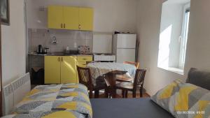 a kitchen with yellow cabinets and a table with chairs at Villa Morena in Trnovo +13 photos
