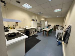 a large kitchen with white counters and a table at Le Lilas - 6 in Cherbourg en Cotentin