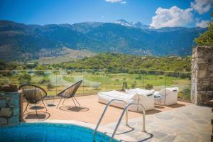 a pool with chairs and a view of a mountain at Traditional Villas Askyfou in Karés