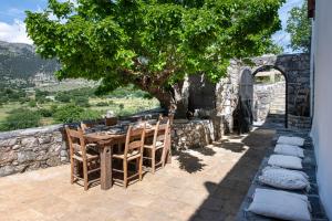 a table and chairs on a patio under a tree at Traditional Villas Askyfou in Karés +43 photos