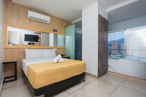 a bedroom with a bed and a bath tub and a bath tub at Hotel Piso 12 in Bello +39 photos