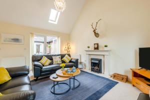 a living room with a leather couch and a fireplace at 2 Bed in Buxted oc-t44744 in Buxted