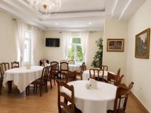 a dining room with tables and chairs and a chandelier at Aleksov Complex Aleksion Palace in Ognyanovo