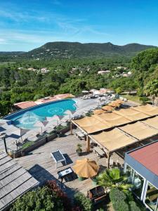 an aerial view of a resort with a pool and umbrellas at U Paesolu in Sainte-Lucie de Porto-Vecchio