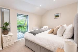 a bedroom with a large white bed and a window at COTTON HOUSE - Peak District Escape, Walks, Canal & Cromford Mill in Matlock