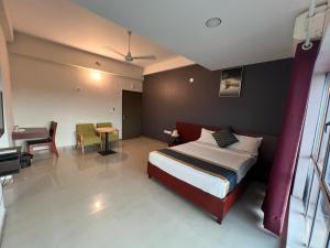a bedroom with a bed and a table and a desk at Peace Residency in Jāmb
