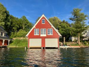 a red house in the middle of a body of water at Seehaeuser am Lindenhof in Lychen