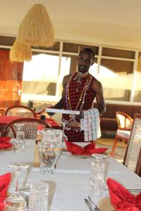 a man is standing in front of a table at Narasha homestay in Talek