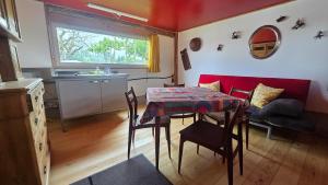 a living room with a table and a red couch at Mutzgraben Lodge in Seeberg